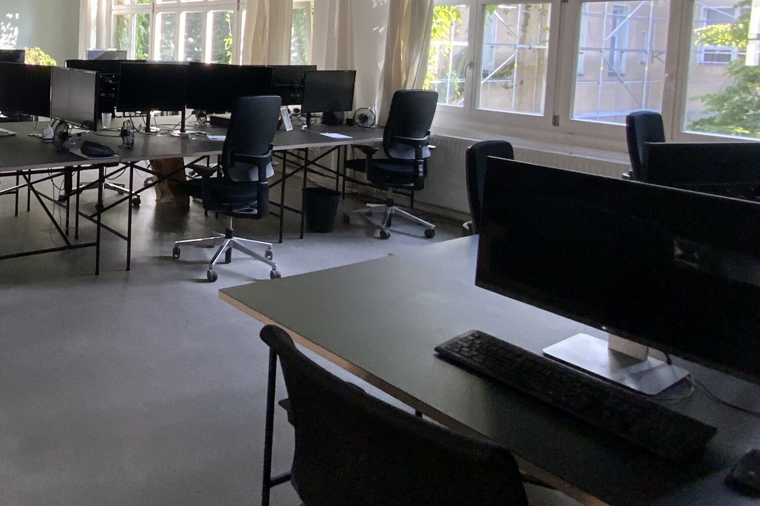 An office with desks, monitors and ergonomic chairs